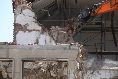 Kazıcı Bulgaristan 'ın Sofya kentinde yeniden inşa için bir binayı yıkıyor. Eski bir binanın tuğla duvarının yıkılması
