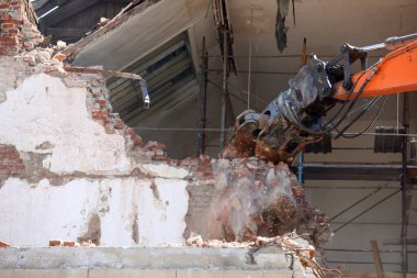 Kazıcı Bulgaristan 'ın Sofya kentinde yeniden inşa için bir binayı yıkıyor. Eski bir binanın tuğla duvarının yıkılması