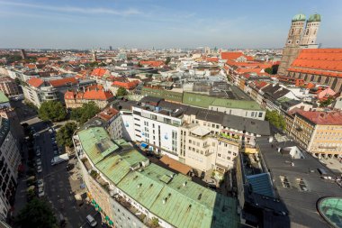 Marienplatz 'ın ve çevrenin manzarası. Turistler şehrin sokaklarında yürürler..