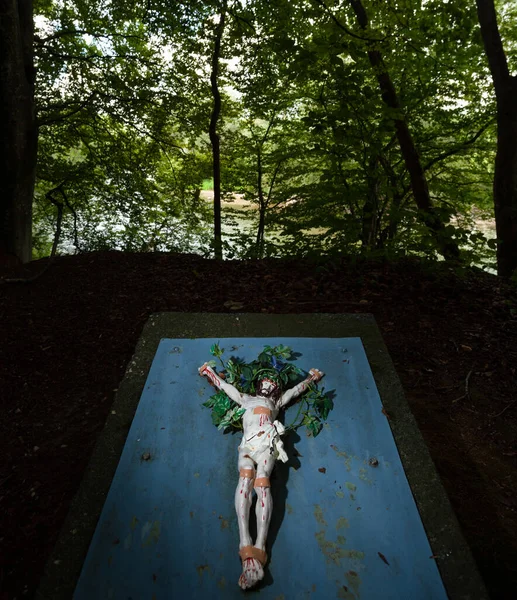 Ancient spiritual image of Jesus Christ on the path in a forest near the city of Emmering in Munich, Germany.