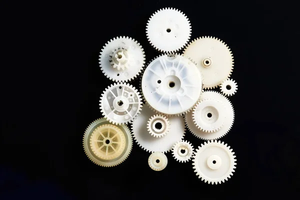 Siyah arkaplanda beyaz plastik dişliler