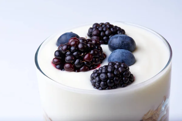 Bir bardak müsli, yoğurt, böğürtlen ve yabanmersini.