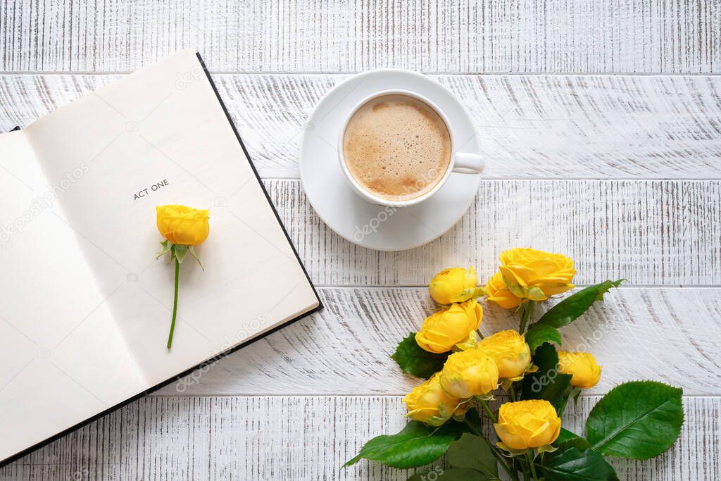 A cup of coffee, yellow roses and open book on the white wooden table. Time for yourself.Top view. Flat lay.