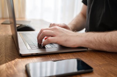 Dizüstü bilgisayarda erkek el yazısı. Evden online çalışan bir adam.