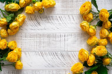 Beyaz ahşap arka planda sarı güller. Üst Manzara. Boşluğu kopyala.