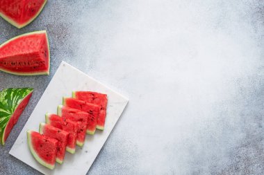 Mermer tepside karpuz dilimleri ve beton zeminde karpuz parçaları..