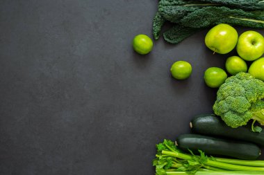 Kereviz, kabak, lahana, brokoli, elma ve limon manzarası. Siyah arka planda yeşil sebzeler. Sağlıklı yaşam tarzı.