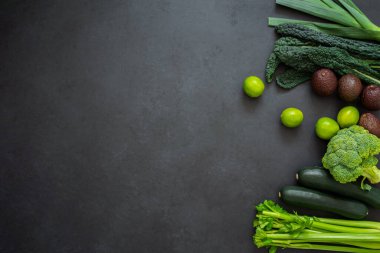Kereviz, kabak, lahana, brokoli, pırasa, avokado ve limon manzarası. Siyah arka planda yeşil sebzeler ve fotokopi alanı. Sağlıklı yaşam tarzı.