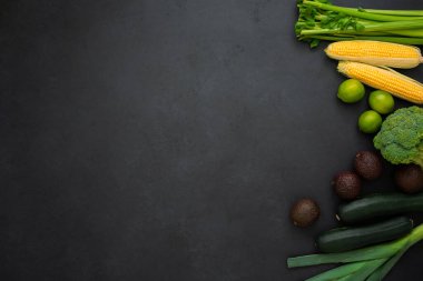 Siyah arka planda, kopyalama alanı olan çeşitli sebzeler. Kereviz, mısır, brokoli, avokado, kabak, pırasa ve limon. Sağlıklı yaşam tarzı.