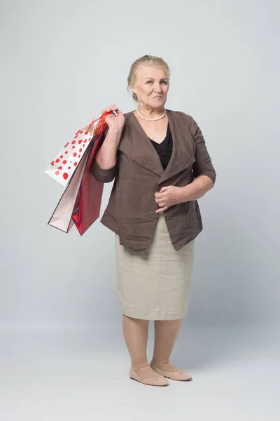 an old woman holding shopping bags