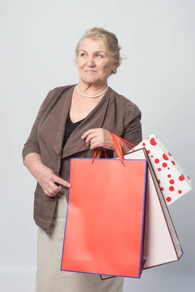 an old woman holding shopping bags