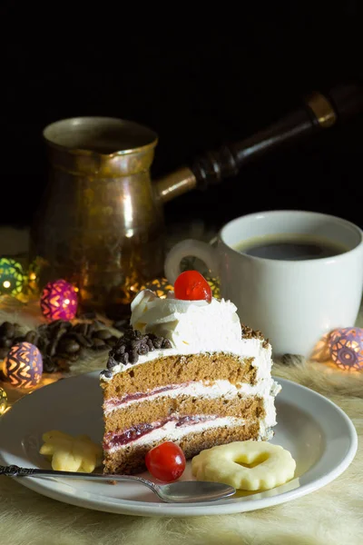 Portion of vanilla and cream cake served on a plate with cookies and coffee