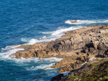 İspanya sahillerinde gün batımında dalgalar ve uçurumlar