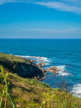 İspanya sahillerinde gün batımında dalgalar ve uçurumlar