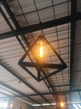 Duvara asılmış sanatsal bir lamba. Kahve dükkanında sanayi tipi lamba..