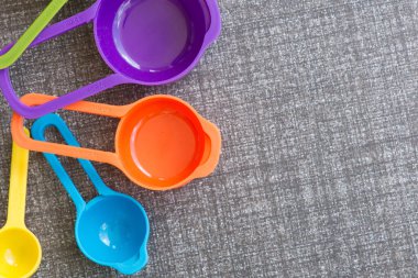 Mutfak zemininde renkli ölçüm bardakları.