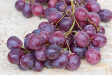 Tahta tabakta kırmızı üzüm demetleri
