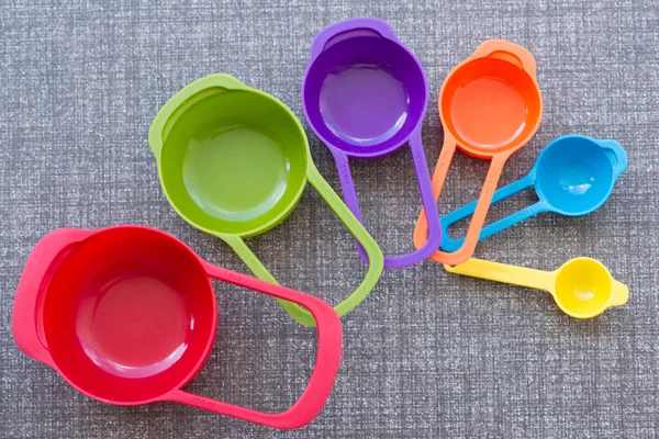 colorful measuring cups on kitchen floor.