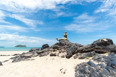 Kaya üzerinde deniz kızı heykeli olan gökyüzü ve sahil manzarası; Songkhla Tayland