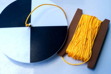 Beyaz bir masada ipi olan Secchi diski, su şeffaflığı ölçümüne hazır..