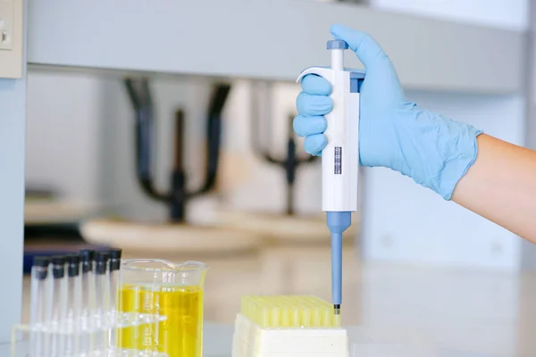 在化学实验室工作的科学家 带着自动装置 戴着蓝色手套 — 图库照片