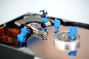 Minyatür işçiler sabit disk sürücüsünü tamir ediyor                               