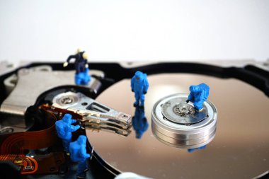 Minyatür işçiler sabit disk sürücüsünü tamir ediyor                              