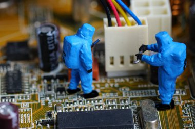 Bilgisayar teknisyenleri ana güvertede tamir ediyorlar. Minyatür insanlar.                               