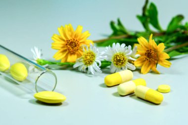 Sarı ve beyaz çiçekli ilaç hapları.