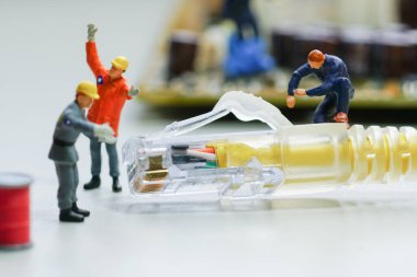 Teknisyenler kablo şebekesini onarmaya çalışıyorlar. Minyatür insanlar.                                