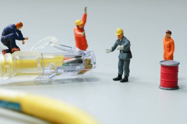 Teknisyenler kablo şebekesini onarmaya çalışıyorlar. Minyatür insanlar.                                