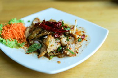 Ahşap masada ızgara domuz salatası.