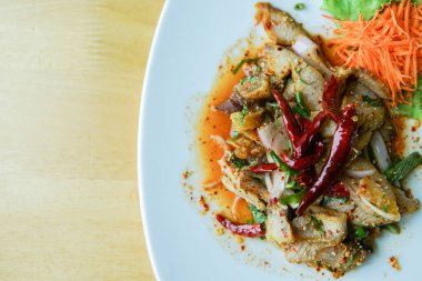 Ahşap masada ızgara domuz salatası.