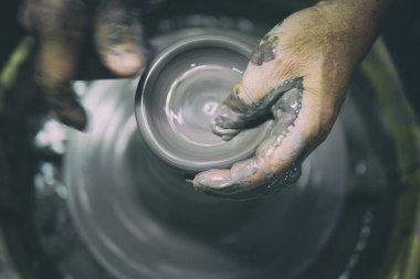 Potter iş yerinde. Çömlek çarkında seramik çömlek yapan adam.