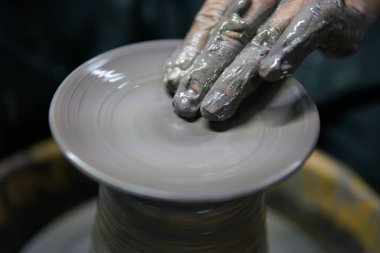 Potter iş yerinde. Çömlek çarkında seramik çömlek yapan adam.