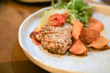 Tahta masada beyaz diskte domuz bifteği.