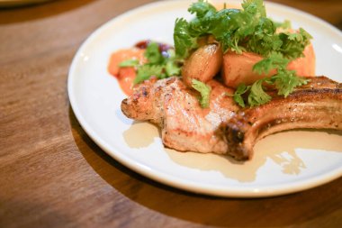 Ahşap masadaki domuz eti lokantası bifteği..