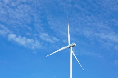 Rüzgar türbinleri mavi gökyüzü ile elektrik üretiyor, yenilenebilir enerji kaynağı