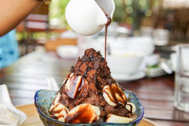 Çikolatalı bingsu mu yoksa üstünde muz olan buz tanesi mi? Tatlı.