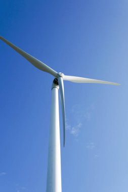 Rüzgar türbinleri mavi gökyüzü ile elektrik üretiyor, yenilenebilir enerji kaynağı