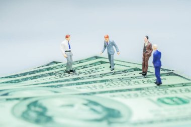 Minyatür insanlar: Amerikan doları banknotları olan iş adamı. İş konsepti.