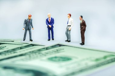 Minyatür insanlar: Amerikan doları banknotları olan iş adamı. İş konsepti.