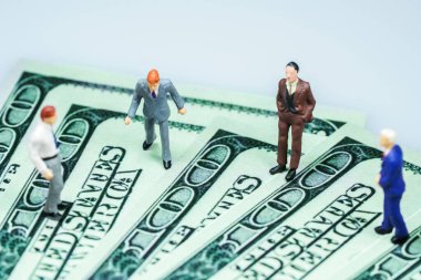 Minyatür insanlar: Amerikan doları banknotları olan iş adamı. İş konsepti.