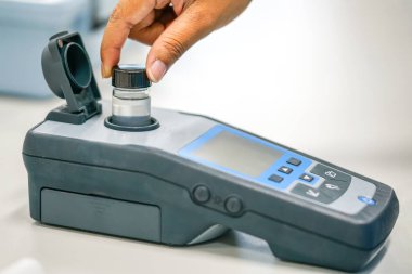 Spektrofotometre tarafından su kalitesi test kullanımında çalışan bilim adamı 