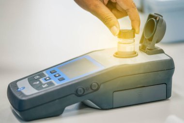 Spektrofotometre tarafından su kalitesi test kullanımında çalışan bilim adamı 
