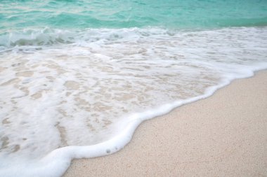 Kumsal ve su dalgalı kum. Deniz köpüğü. Deniz dalgası. Doğa arkaplanı.