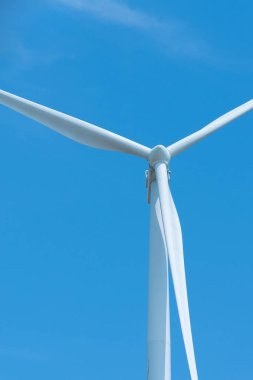 Rüzgar türbinleri mavi gökyüzü ile elektrik üretiyor, yenilenebilir enerji kaynağı