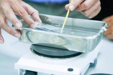 Patoloji laboratuvarında teşhis için doku biyopsisi yapan mikroskop kayması. Leke mikroskopide mikroskobik resimdeki kontrastı arttırmak için kullanılan yardımcı bir tekniktir..