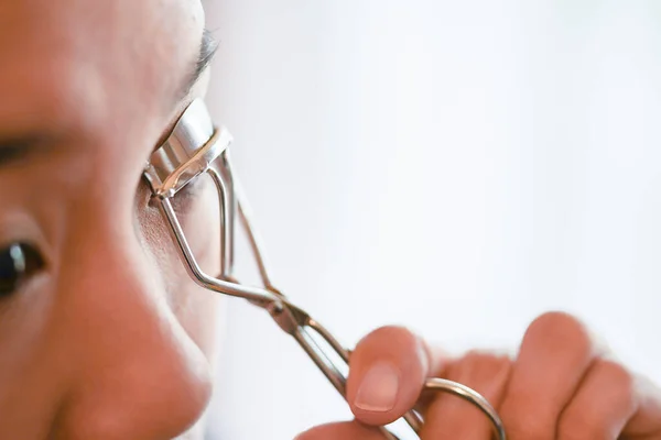 Young woman using eyelash curler. Beauty Makeup.