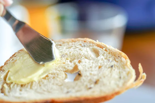 在面包上涂黄油的手 特写镜头 — 图库照片